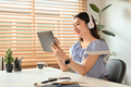 Smiling pretty young woman wearing headphone working online on digital tablet. - PhotoDune Item for Sale
