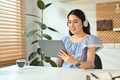 Attractive woman wearing wireless headphone working online on digital tablet. - PhotoDune Item for Sale