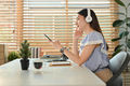 Pleasant young woman in casual clothes holding smart phone and listening to music on headphone. - PhotoDune Item for Sale