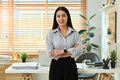 Portrait of beautiful business woman standing in front of her working desk and smiling at camera. - PhotoDune Item for Sale