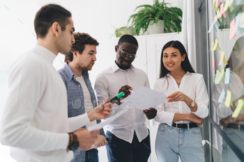 Concentrated diverse colleagues brainstorming against chat board during project work