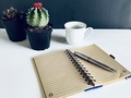 Top view of notebook and pen with coffee and plant  - PhotoDune Item for Sale