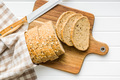 Sliced whole grain bread. Tasty wholegrain pastry with seeds on cutting board. Top view. - PhotoDune Item for Sale