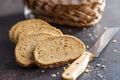 Sliced whole grain bread. Tasty wholegrain pastry with seeds on black table. - PhotoDune Item for Sale