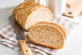 Sliced whole grain bread. Tasty wholegrain pastry with seeds on checkered napkin. - PhotoDune Item for Sale
