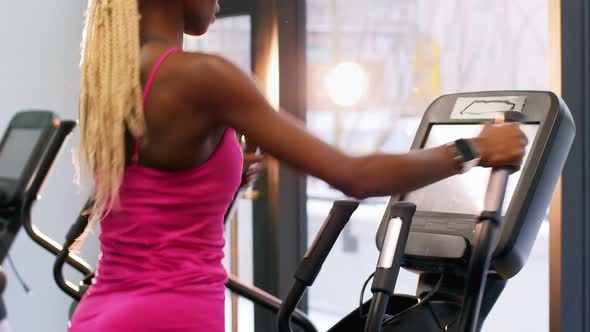 Fit woman exercising on cross trainer