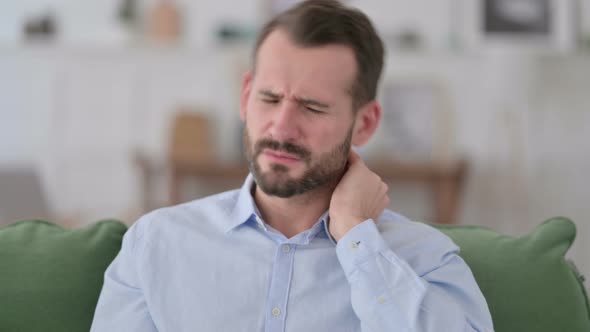 Young Man with Neck Pain at Home 