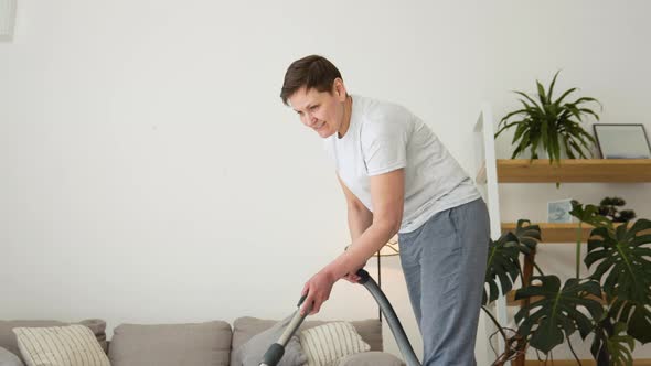 Senior Woman Vacuuming Carpet at Home