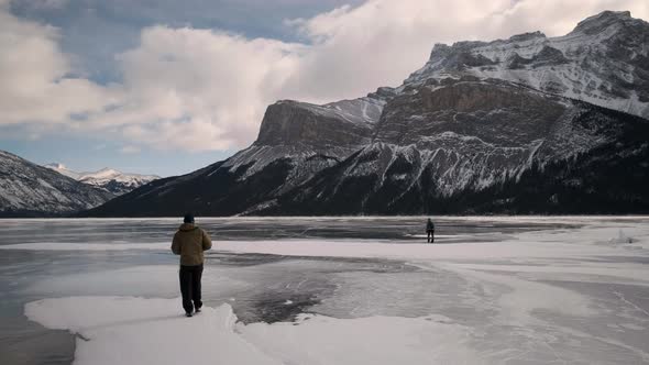 Tourists Discover an Amazing Winter Landscape in Banff Alberta Canada. Two People in Warm Coats Expl