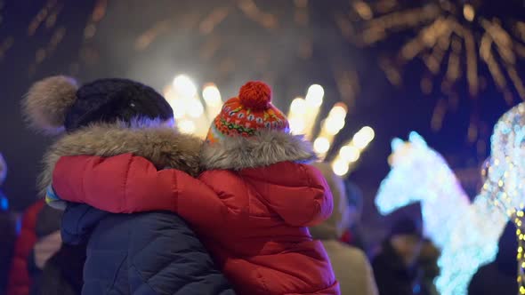 Mother and Son Look at the Fireworks in the Night Sky. Slowmotion Shot