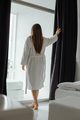 Woman in white bathrobe opening curtains in room - PhotoDune Item for Sale