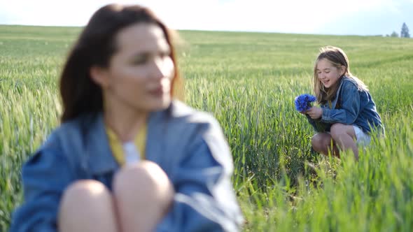 Happy Mother and Daughter Walking in a Green Field in the Countryside Family Having Fun