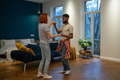 Romantic interracial young family couple wife and husband dancing to music together at home - PhotoDune Item for Sale