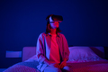 Impressed young woman sitting on bed at home watching 3d video in VR, traveling in virtual reality - PhotoDune Item for Sale