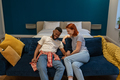 Happy diverse friends man and woman sit on sofa enjoy pleasant conversation while meeting at home - PhotoDune Item for Sale