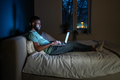 Black student guy lying in bed with laptop in evening, studying until late hours - PhotoDune Item for Sale
