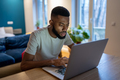 Focused African American guy freelancer working on laptop at home office, feeling overwhelmed - PhotoDune Item for Sale