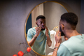 Unhappy worried young African man looking in mirror touching wrinkles on face - PhotoDune Item for Sale