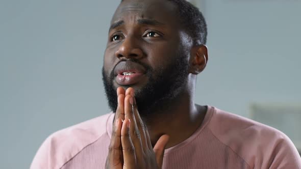 Worried Black Man Watching Game on TV, Praying for Victory and Celebrating Goal