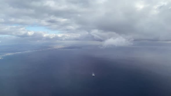 Thick Grey Clouds Float Slowly Above Navy Ocean with Ship