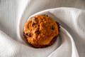 Muffins with raisins on a wooden background. Cupcake in a paper mold on a white napkin. - PhotoDune Item for Sale