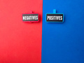 Wooden board with the word NEGATIVES POSITIVES on red and blue background. - PhotoDune Item for Sale