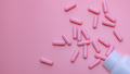 Pink capsule pills spread out of plastic drug bottle. Woman's health insurance and breast cancer - PhotoDune Item for Sale
