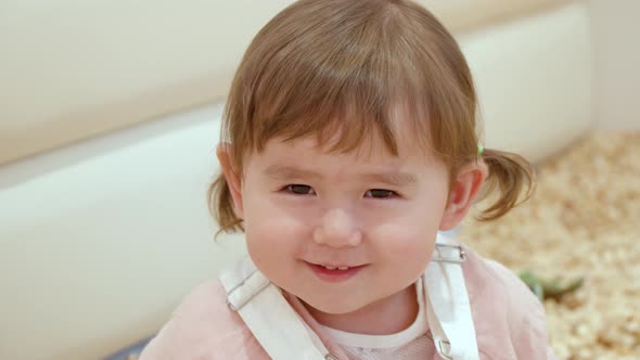 Charming And Lovely Face Of A Little Girl Smiling In Front Of Camera. Close Up Shot