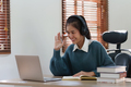 Asian woman having video call on her laptop computer at home. listening to online lecture, taking - PhotoDune Item for Sale