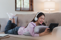 Attractive Asian woman resting comfortable living room and using digital tablet, Relax, Sofa - PhotoDune Item for Sale