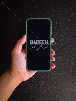 Fintech (financial technology) on smart phone concept. Hand with smart phone and text fintech