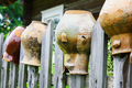 Old broken clay jugs on wooden fence - PhotoDune Item for Sale