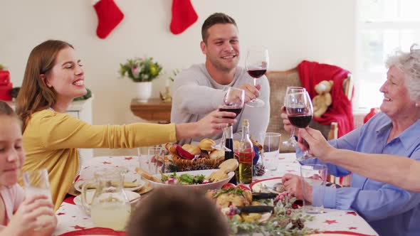 Caucasian family toasting while sitting on dining table