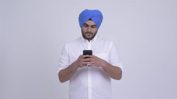 Happy Young Bearded Indian Sikh Man Using Phone