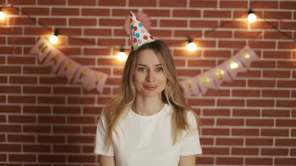 Woman Celebrates a Holiday with a Cap on Her Head