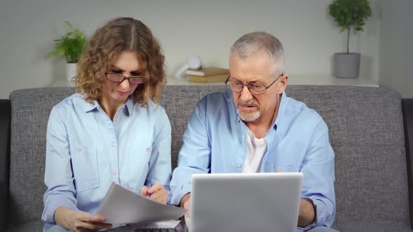 A Couple in Front of a Laptop Discuss Financial Calculations