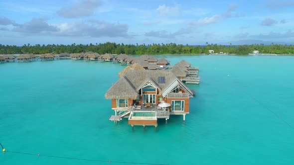 Aerial drone view of a luxury resort and overwater bungalows in Bora Bora tropical island.