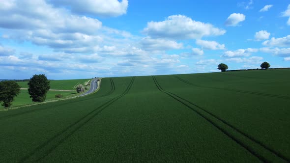 Drone flying over beautiful green harvested field in Wiltshire countryside, England