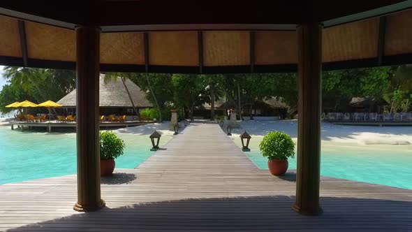 View of a tropical island dock pier over a beach.