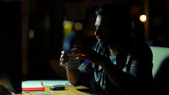 Business executive having coffee while working on computer