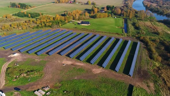 Aerial view of solar panel rows near a forest during Autumn, Estonia.