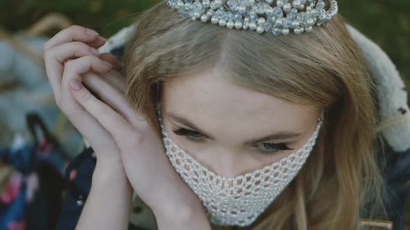 portrait of the bride in a mask posing. Beautiful young bride in a wedding dress in the park. She ha