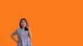 Young asian woman over orange background doing ok sign with hands - PhotoDune Item for Sale