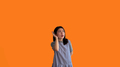 Asian woman eavesdropping or overhearing secret conversation isolated on orange background - PhotoDune Item for Sale