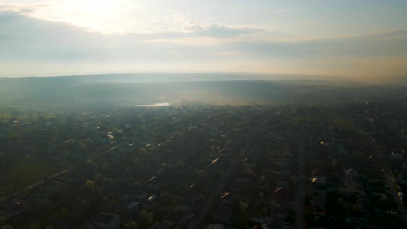 Aerial Above View of Village House and Farm Land in Morning Sunlight