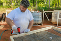 Worker nailing metal mesh to a wooden frame - PhotoDune Item for Sale