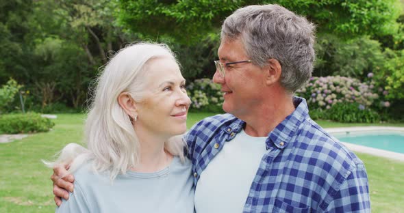 Animation of caucasian senior couple embracing in garden