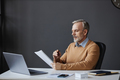 Side view mature man reading document at workplace in office - PhotoDune Item for Sale