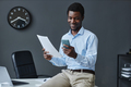 Young black businessman using smartphone sitting on desk in office and - PhotoDune Item for Sale