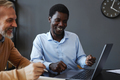 Smiling black young businessman with senior colleague collaborating - PhotoDune Item for Sale